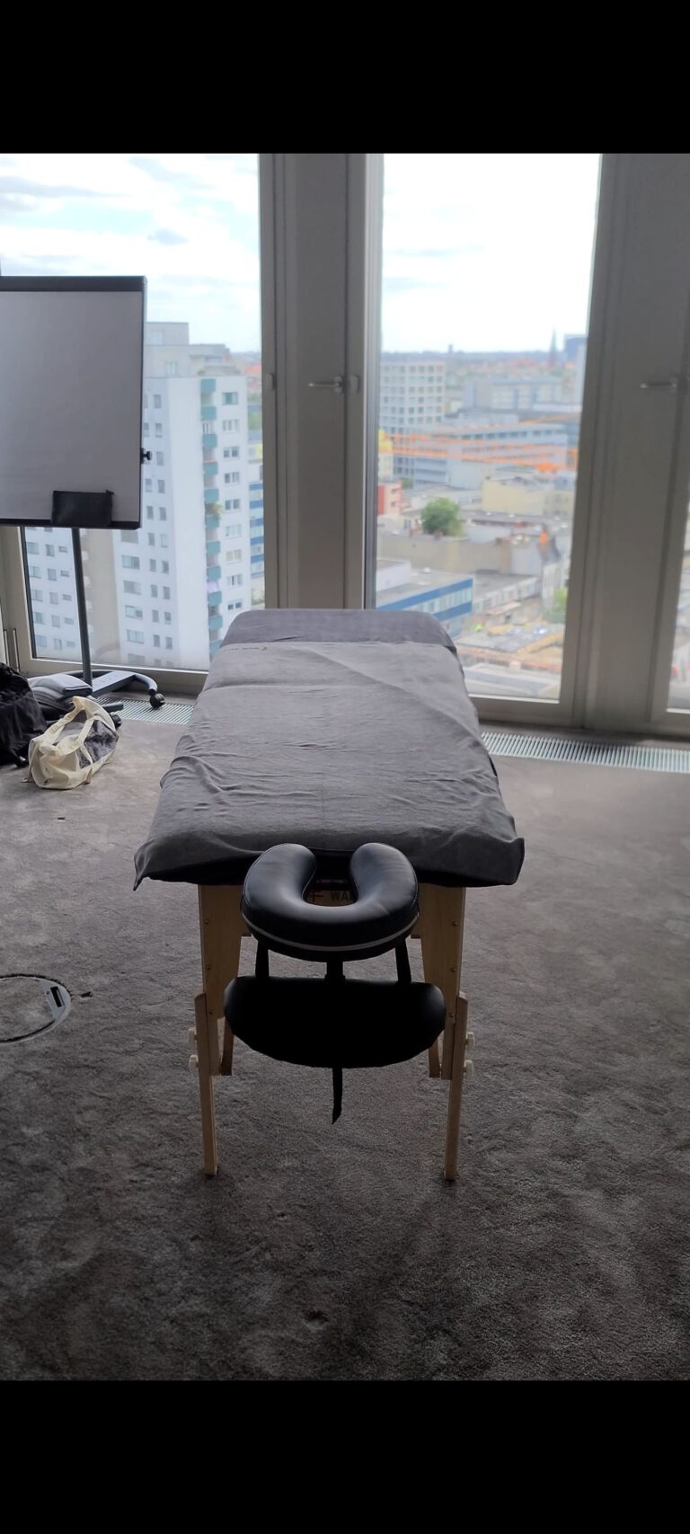 Mobile Massageliege für Massagen am Arbeitsplatz mit Blick über die Berliner Skyline